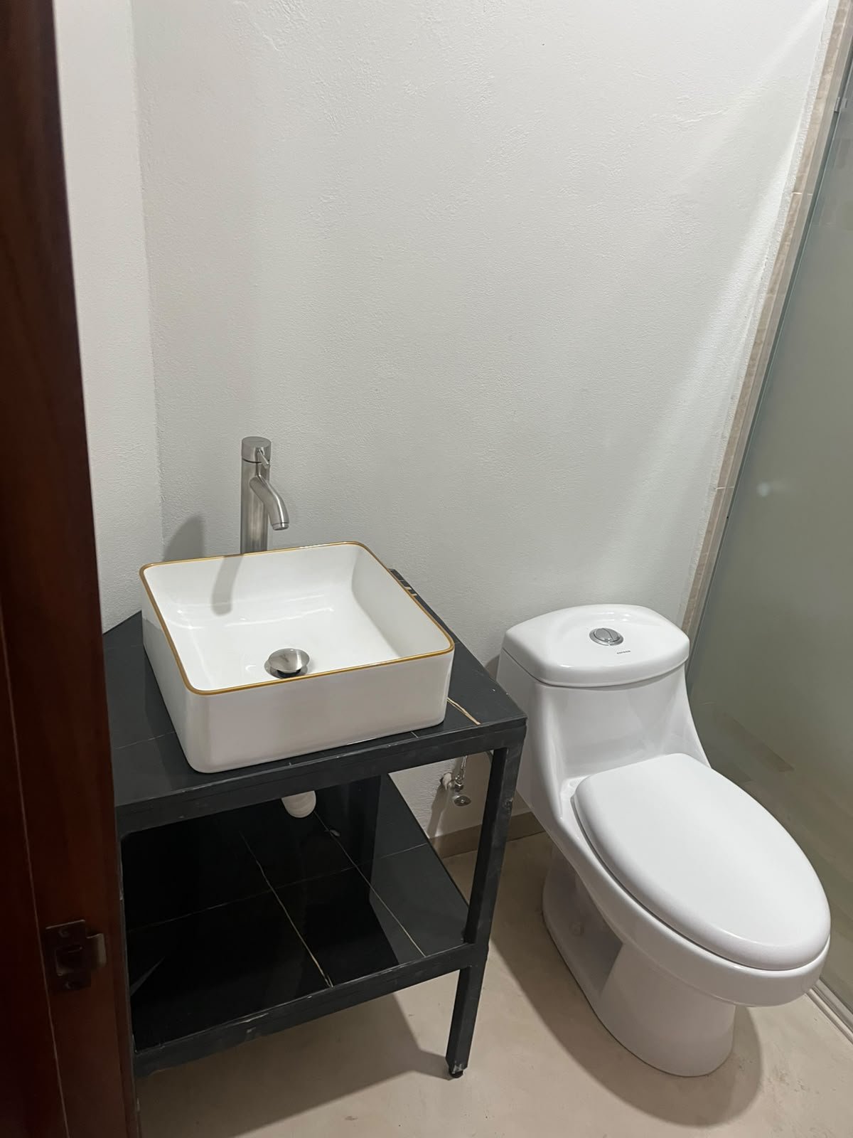 Baño con lavabo sobre mueble de mármol